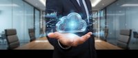 Professional businessman presenting holographic cloud computing technology in modern conference room for digital transformation and data storage solutions.