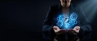 Professional businessman in dark suit holding glowing blue digital brain with gear mechanisms representing artificial intelligence and innovation concepts.