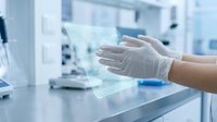 Scientist wearing protective gloves interacting with holographic display in modern laboratory environment with advanced technology and equipment.