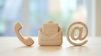 Wooden contact icons phone envelope and email symbol on desk representing customer service and business communication methods.