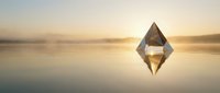 Crystal diamond floating above calm water surface during golden hour sunset with perfect reflection creating symmetrical composition for luxury concepts.