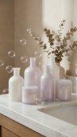 Minimalist spa cosmetic bottles and jars with eucalyptus branches and soap bubbles on marble surface creating serene wellness atmosphere for skincare branding.