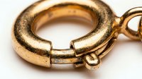 Gold spring ring clasp jewelry fastener closeup showing detailed metalwork and craftsmanship for luxury accessories and fine jewelry making supplies.