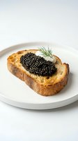 Toasted bread slice topped with creamy spread and luxurious black caviar, garnished with fresh dill on white plate. Gourmet appetizer for fine dining and upscale cuisine.