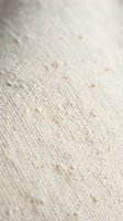 Natural linen fabric texture with organic cotton fibers and woven pattern in neutral beige tones for textile and fashion design backgrounds.
