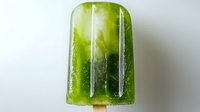 Refreshing green kiwi popsicle with visible fruit pieces frozen inside, perfect for summer dessert menus and healthy eating content.