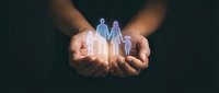 Hands holding glowing family figures representing protection, care and insurance coverage for loved ones in dark background.