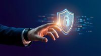 Businessman hand holding glowing digital security shield with padlock icon surrounded by data streams, representing cybersecurity protection and network defense technology.