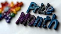 Colorful text spelling Pride Month in metallic gradient letters with rainbow butterfly decoration against white background, celebrating LGBTQ+ community and diversity.