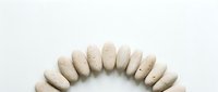 Beige oval nail polish swatches arranged in semicircle on white background, showcasing neutral tones for manicure design and cosmetic product display.