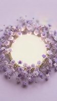 Delicate purple baby's breath flowers arranged in circular wreath frame on soft lavender background with copy space for text or product placement.