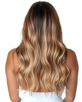 Back view of long wavy blonde balayage hair on woman wearing white top, showing professional modern hair coloring technique with smooth gradient from dark to light.