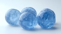 Translucent blue ice spheres on white background, frozen round balls with crystalline texture for cooling drinks or creative food photography.