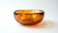 Amber glass bowl with swirling golden brown tones, isolated on white background, ready for design use in home decor and product presentations.
