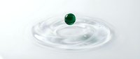 Green sphere floating above clear water ripples creating concentric circles on white background for science physics concepts and abstract designs.