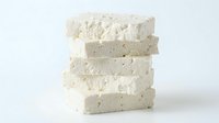 Stacked slices of fresh tofu with visible texture and speckles, isolated on white background for food and culinary design projects.
