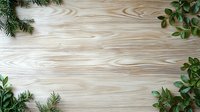 Fresh green pine branches and eucalyptus leaves creating natural frame border on light wooden background with copy space for seasonal design.