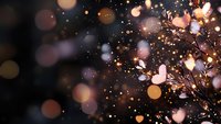 Festive golden and rose particles burst across dark background with bokeh lights, creating elegant celebration atmosphere for holiday designs and event promotions.