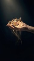 Hand holding glowing golden liquid with sparkling particles flowing downward against dark background, symbolizing wealth, success, and prosperity for business concepts.
