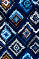 Colorful ethnic geometric diamond pattern with traditional tribal motifs in blue, white, red and yellow colors for textile and fabric design projects.
