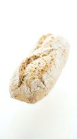 Rustic artisan bread loaf with crusty golden surface isolated on white background for culinary and bakery designs.