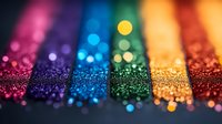 Vibrant stripes of glitter in rainbow colors with bokeh effect create magical sparkly background pattern. Macro photography shows detailed texture of shimmering particles.