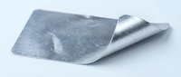 Silver metallic foil sheet with curved corner on white background, isolated for packaging design, craft projects and industrial applications.