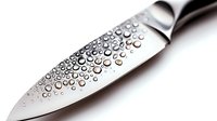 Water droplets on stainless steel chef knife blade, showcasing clean metallic surface with condensation pattern for culinary and kitchen equipment photography.