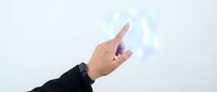 Hand reaching toward glowing digital holographic interface with futuristic light effects on white background for technology and innovation concepts.