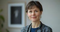 Confident Caucasian female doctor with stethoscope smiling in modern clinic office, portrait of professional healthcare physician.