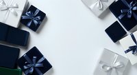 Luxury gift boxes with blue and silver ribbons arranged on white background, overhead flat lay composition for holiday shopping, celebrations, and festive occasions.