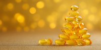 Golden omega-3 fish oil capsules stacked in pyramid shape against blurred bokeh background, highlighting health supplements for wellness.