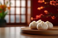 Fresh steamed dumplings on wooden plate in traditional Asian restaurant setting with warm autumn lighting and blurred interior background.