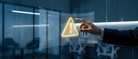 Businessman in dark suit pointing at glowing warning alert icon on digital interface with stock market data, representing cybersecurity risk and financial threat detection in modern office.