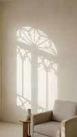 Elegant window shadow casting gothic arch pattern on minimalist beige wall with modern armchair and wooden side table creating serene interior atmosphere.
