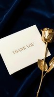 Elegant thank you card with gold foil text beside a golden rose on dark navy blue velvet fabric, luxury gratitude concept.