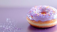 Glazed donut with colorful rainbow sprinkles on purple background with bokeh effect. Sweet pastry macro photography with selective focus and soft lighting.
