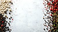Mixed peppercorns frame composition with white, black, pink, and green varieties scattered on light textured background, creating border design for food styling.