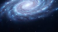 Spiral galaxy with glowing blue and purple nebula clouds rotating in deep space, surrounded by distant stars and cosmic dust formations.