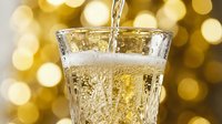Champagne pouring into glass with golden bokeh background, celebration beverage for parties, weddings, and festive occasions.