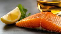 Fresh salmon fillet with lemon wedge and olive oil, ready for cooking. Healthy protein source for culinary, nutrition, and food photography projects.