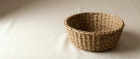 Handwoven wicker basket with natural brown texture on neutral background for home decor and storage solutions.