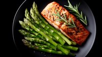 Grilled salmon fillet with fresh asparagus spears and rosemary herb garnish on dark plate, healthy protein meal for restaurant menu and cooking content.