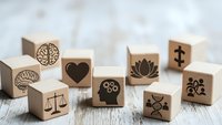 Wooden blocks with mental health and wellness symbols including brain, heart, lotus, scales, DNA on rustic surface for mindfulness and psychology concepts.