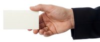 Professional businessman hand holding blank white business card ready for corporate branding and contact information on isolated background.
