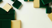 Luxury gift boxes in emerald green and gold arranged on white background, overhead flat lay composition for holiday, celebration, and retail design projects.