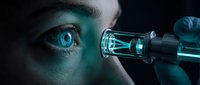 Young adult male with fair complexion and striking blue eyes examining scientific specimen through glass laboratory equipment against dark background for research and analysis.