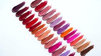 Colorful lipstick swatches arranged in rows showing various shades from deep burgundy to bright pink and coral tones for makeup and beauty concepts.
