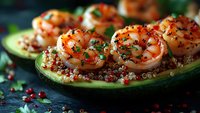 Grilled shrimp served on avocado boats with quinoa, fresh herbs and pink peppercorns, garnished with microgreens on dark background, close up view.