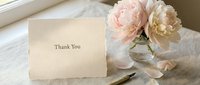 Elegant thank you card beside soft pink peonies in a glass vase on a linen surface, evoking romance, gratitude, and timeless style.
